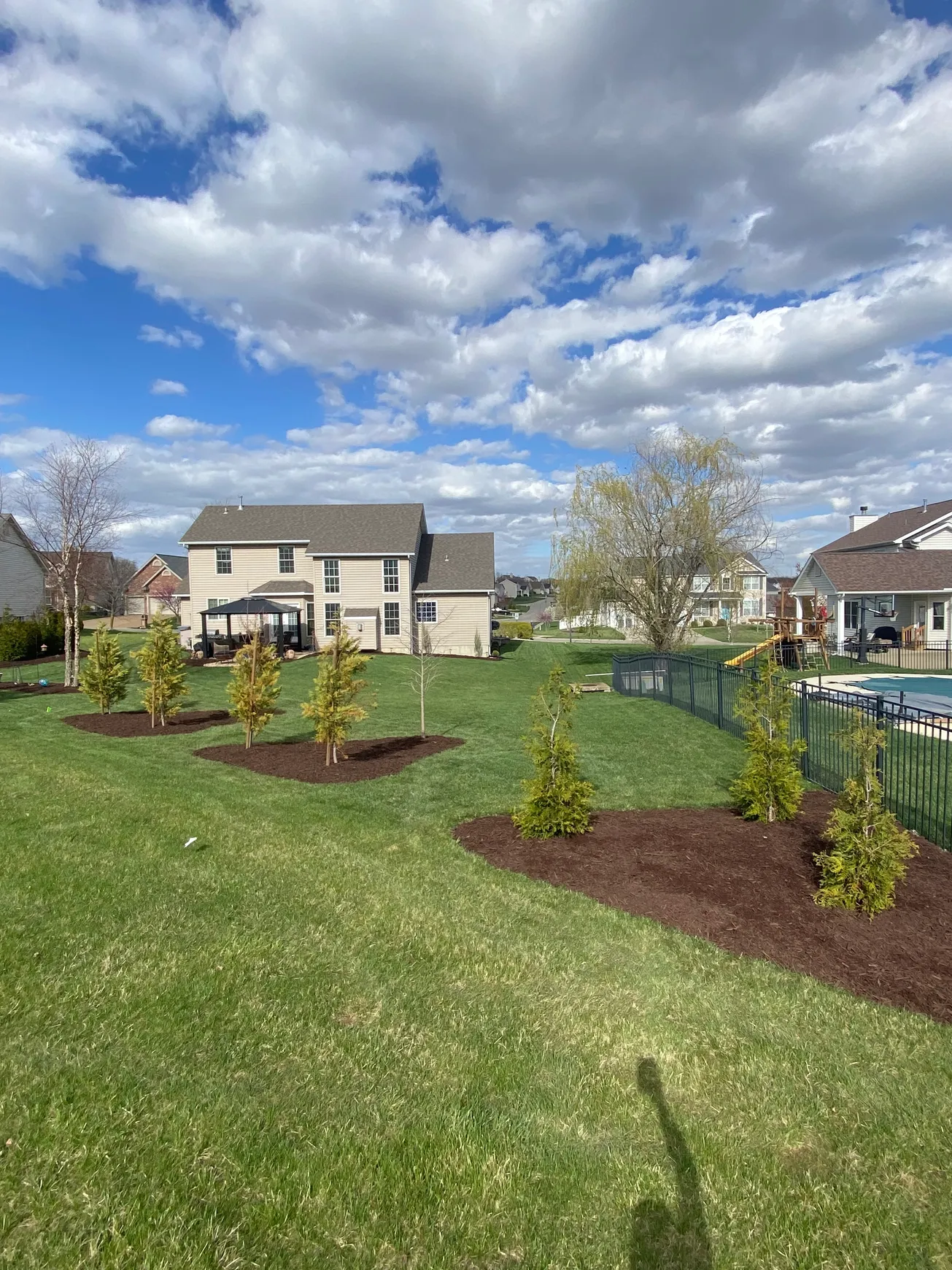 Fresh mulch beds around new trees in a Cottleville, Missouri backyard