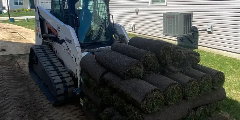 Professional lawn installation service in St. Louis, MO with sod on bobcat machine for new lawn installation